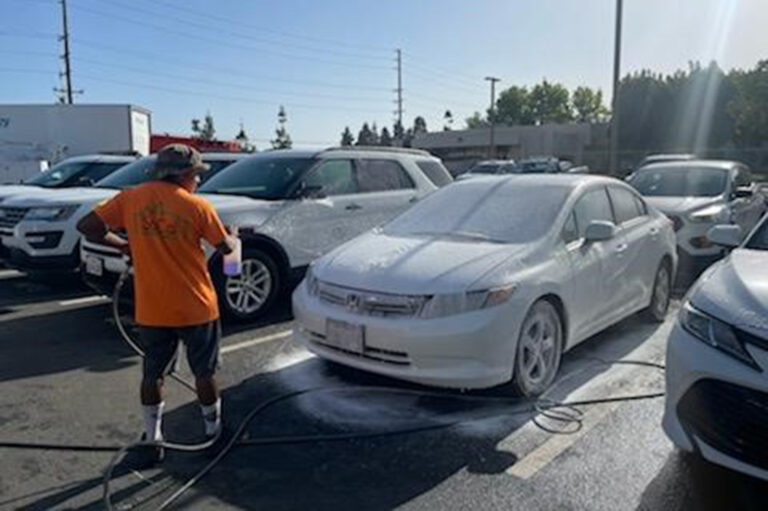 So Cal Property services employee performing fleet washing services with specialized equipment