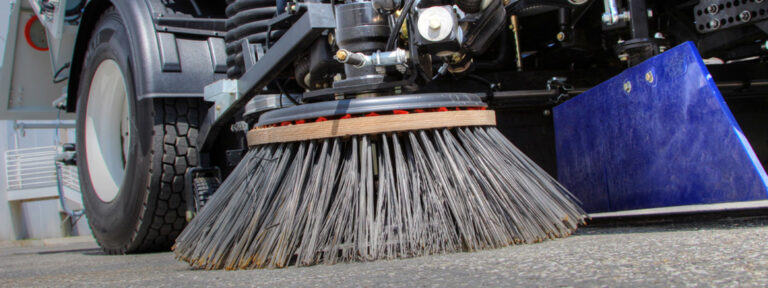 Close up of gutter broom on sweeper truck